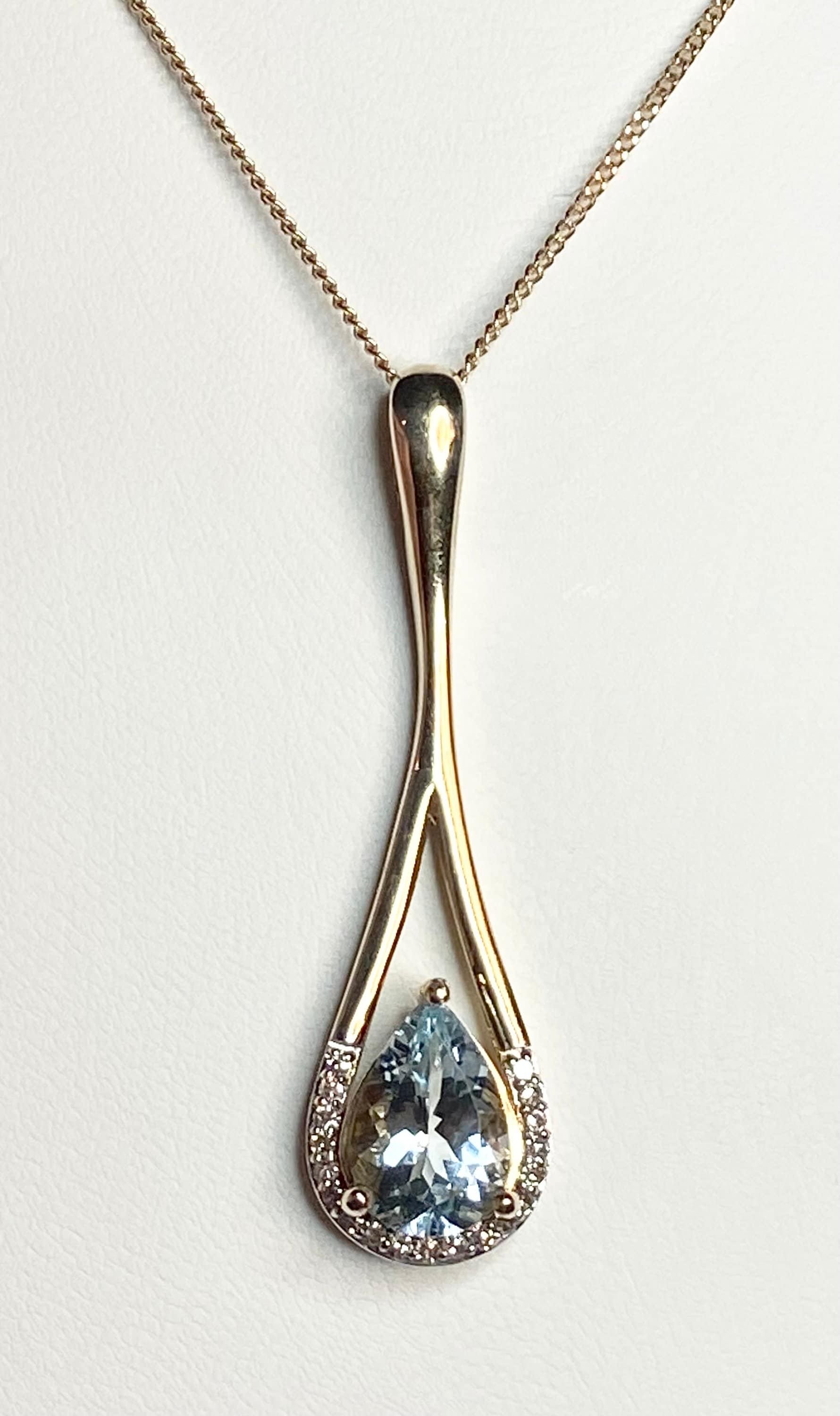 10k gold pendant with pear aquamarine and diamonds on a chain.