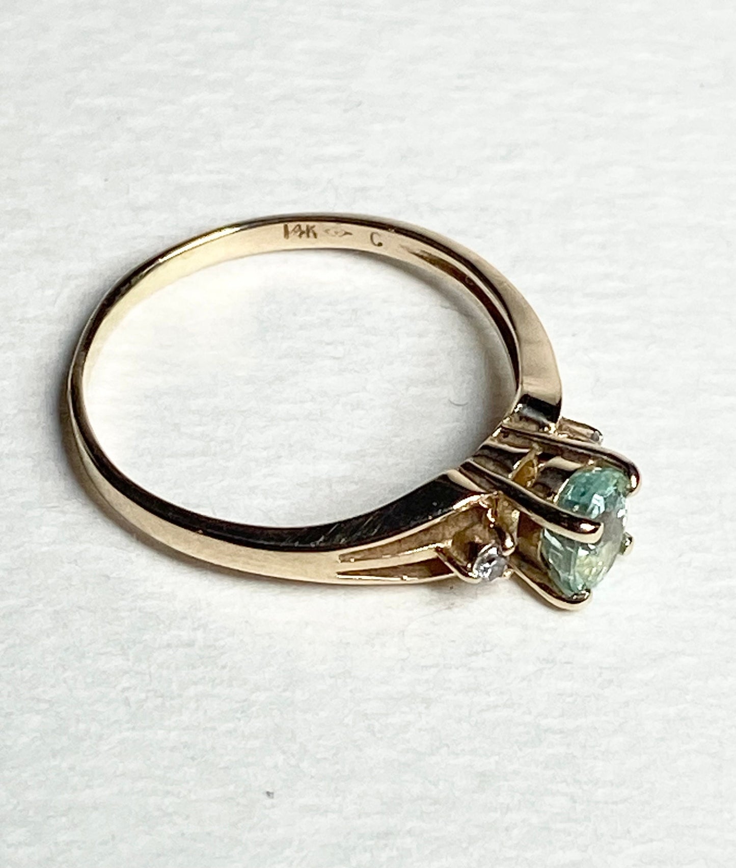 14k gold ring with a green tourmaline and two diamonds.