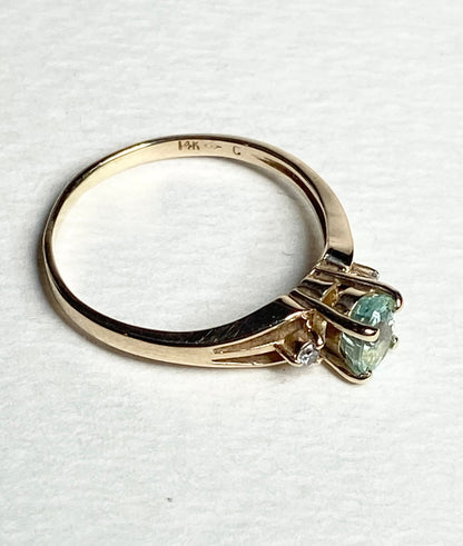 14k gold ring with a green tourmaline and two diamonds.