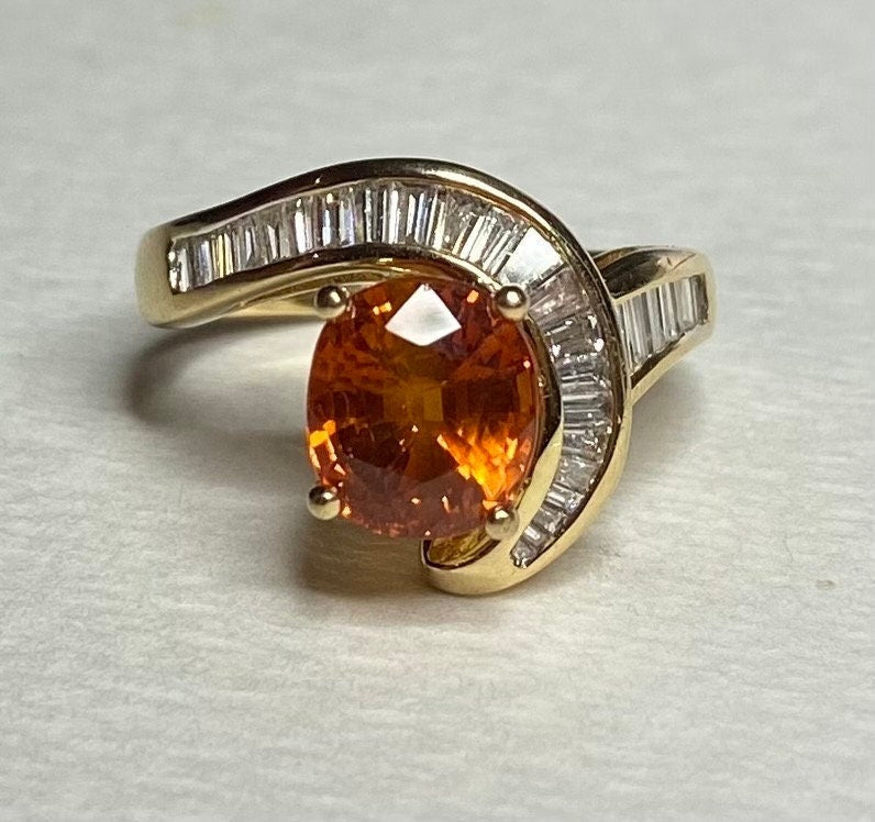 18k yellow gold ring with oval spessartite garnet and baguette diamonds.