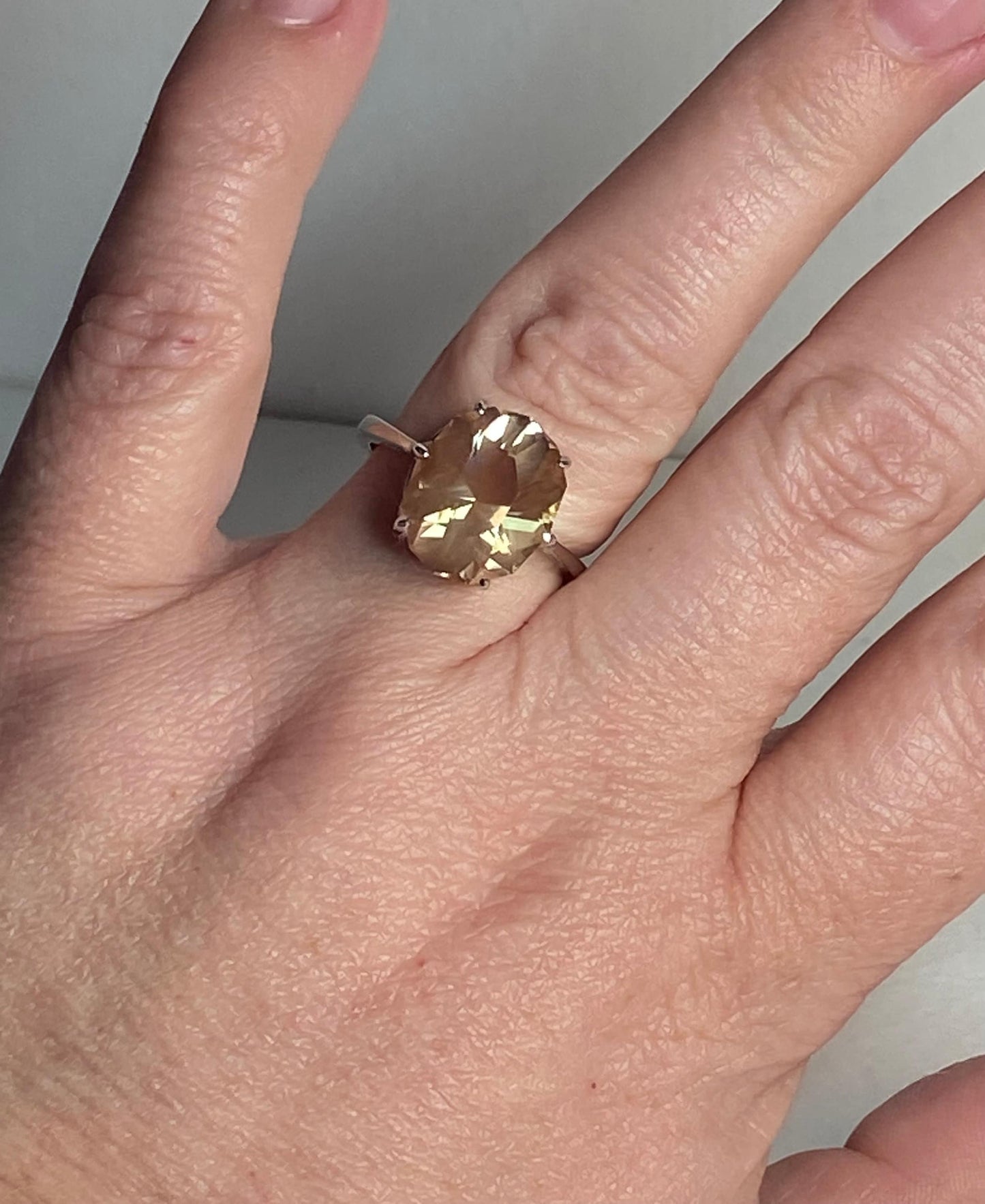 Oval Oregon sunstone ring with a fancy cut in a sterling silver setting.