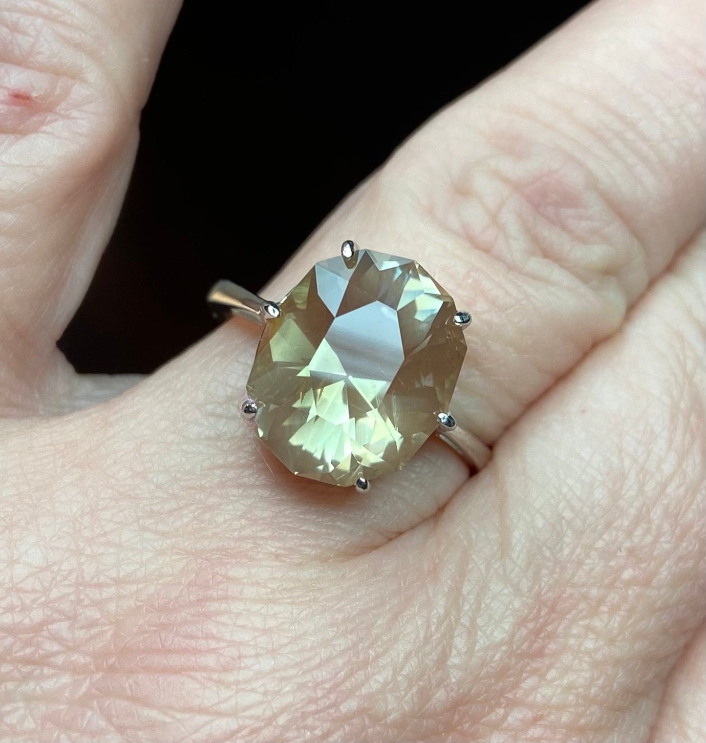 A large oval fancy cut Oregon sunstone ring in a sterling silver setting.
