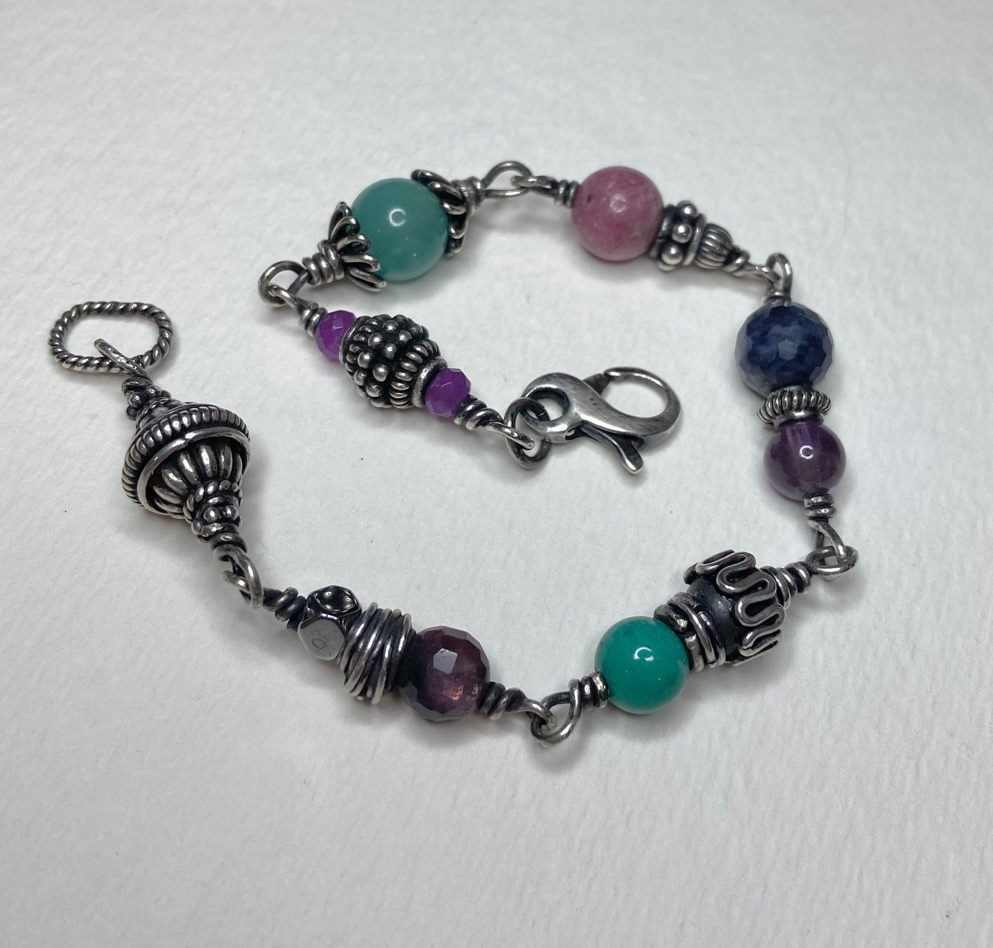 Sterling silver beaded bracelet with multi-colored gemstones and ornate silver accents.