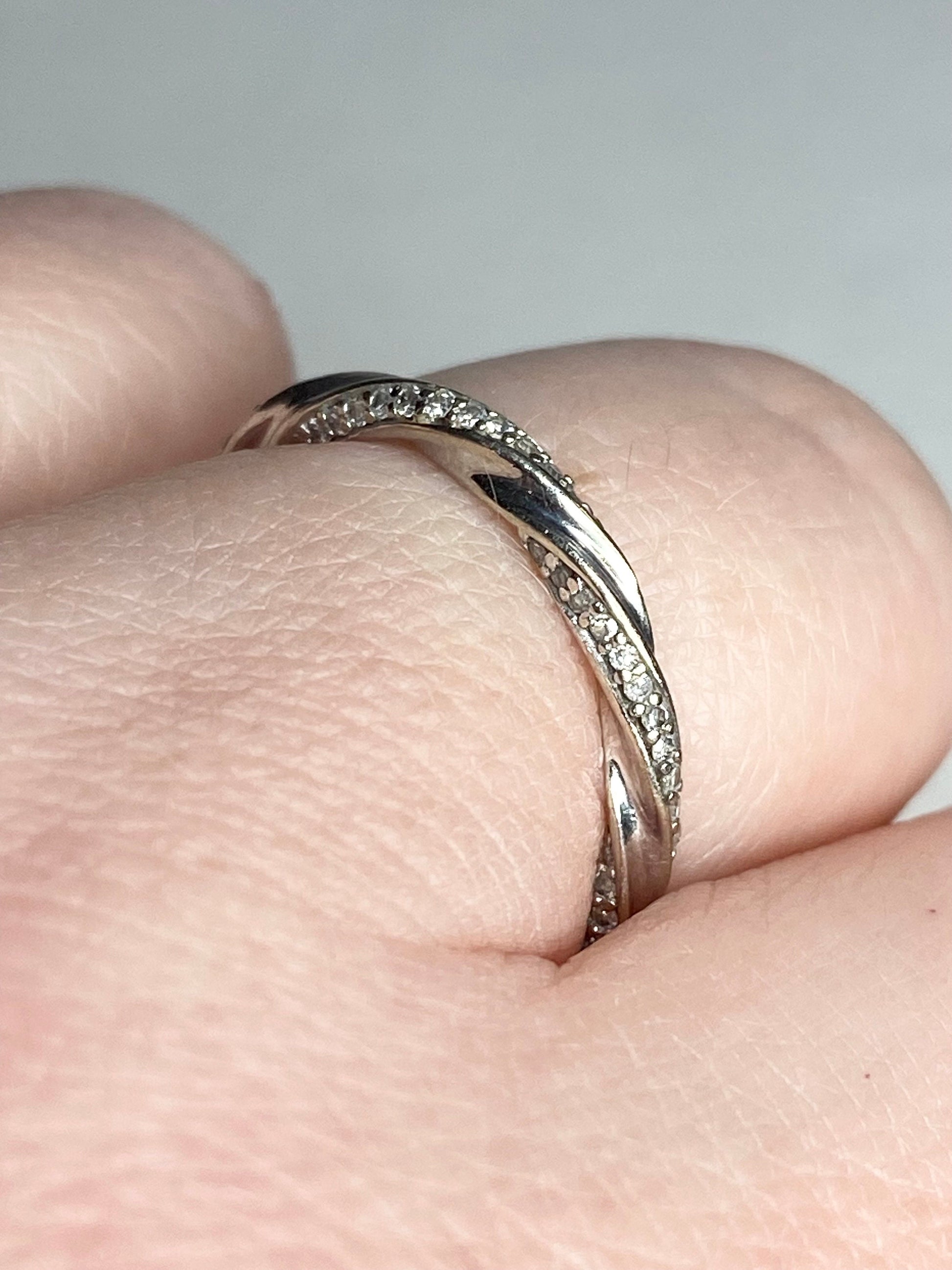 A twisted 10k white gold eternity band ring with 72 natural diamonds.