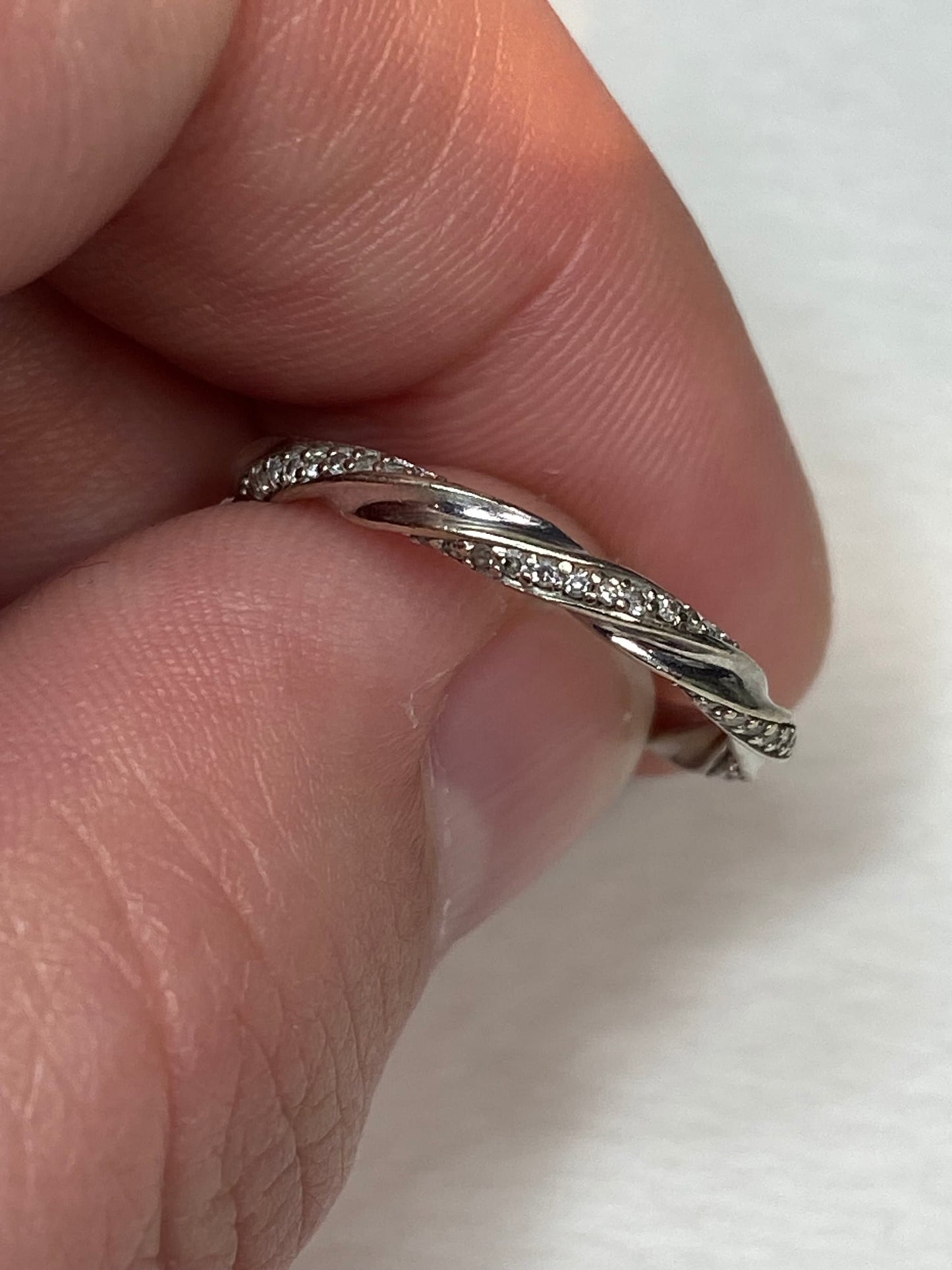 A twisted 10k white gold eternity band ring with 72 small diamonds.