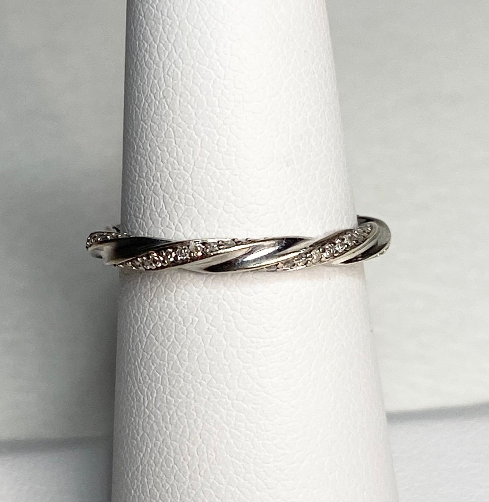A twisted 10k white gold eternity band ring with 72 natural diamonds.