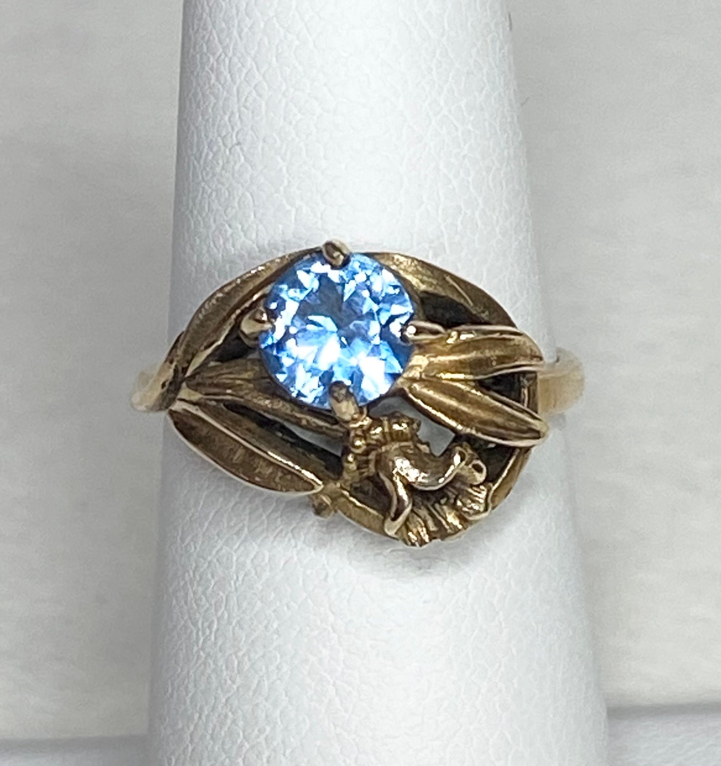 Art Nouveau style 10k yellow gold ring with a blue synthetic spinel and floral design.