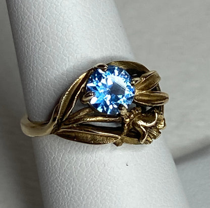 Art Nouveau style 10k yellow gold ring with a blue synthetic spinel and floral design.