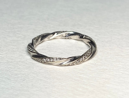 A twisted 10k white gold eternity band ring with 72 small diamonds.