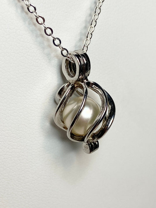 Sterling silver cage pendant with a soft cream Akoya pearl on a cable chain.