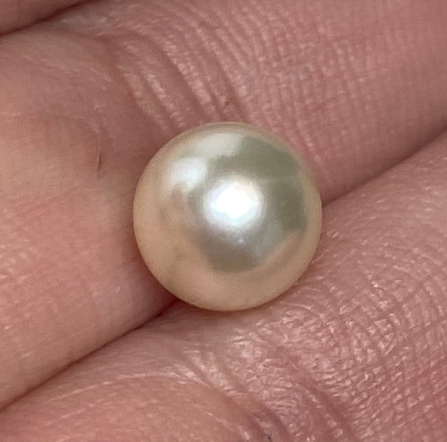 Soft cream Akoya pearl in a sterling silver cage pendant.