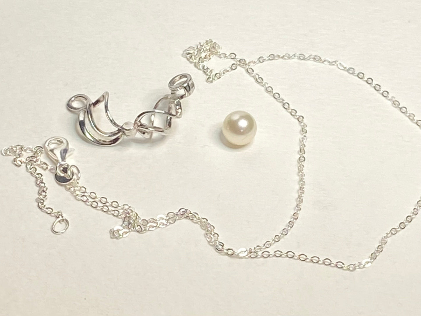 Sterling silver pendant with a pearl in a cage and a cable chain.