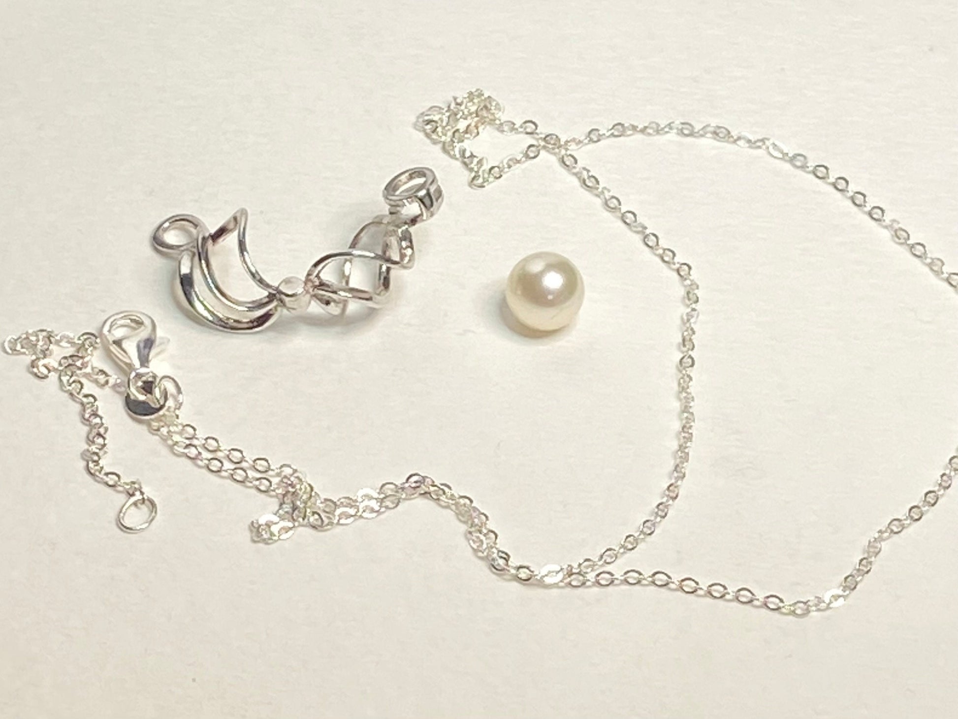 Sterling silver pendant with a pearl in a cage and a cable chain.