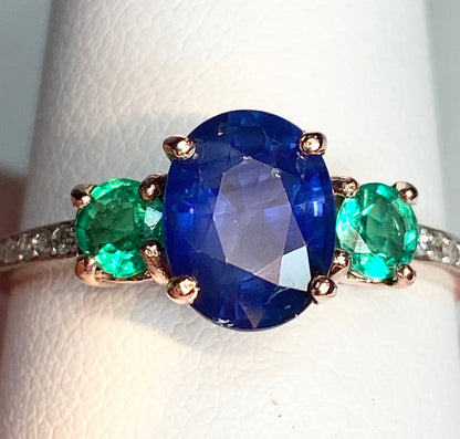 Oval blue sapphire ring with emeralds and diamonds in rose gold.