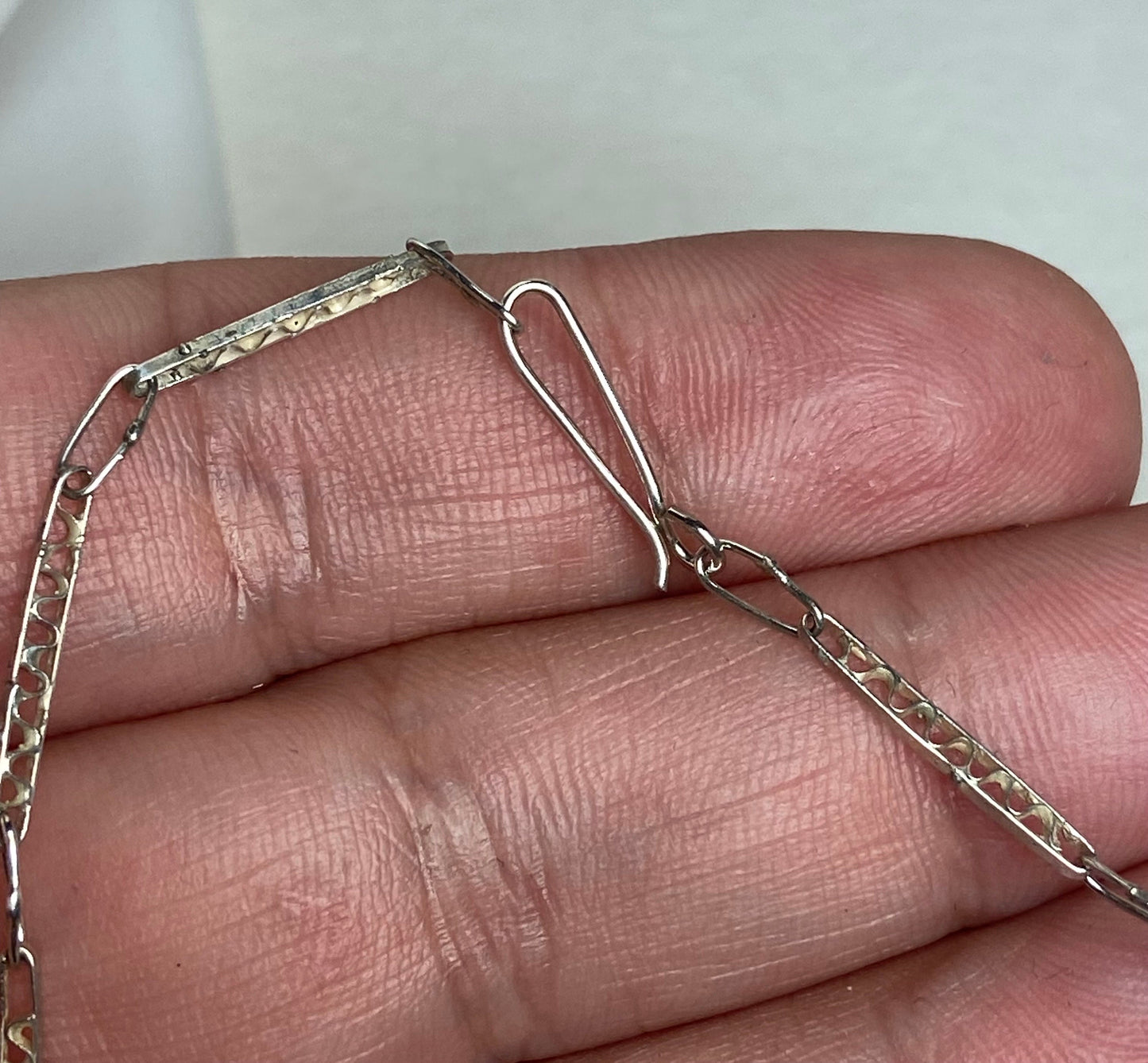 Antique sterling silver filigree cross pendant with a hook clasp chain.