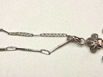 Antique sterling silver cross pendant with filigree detail and matching chain.