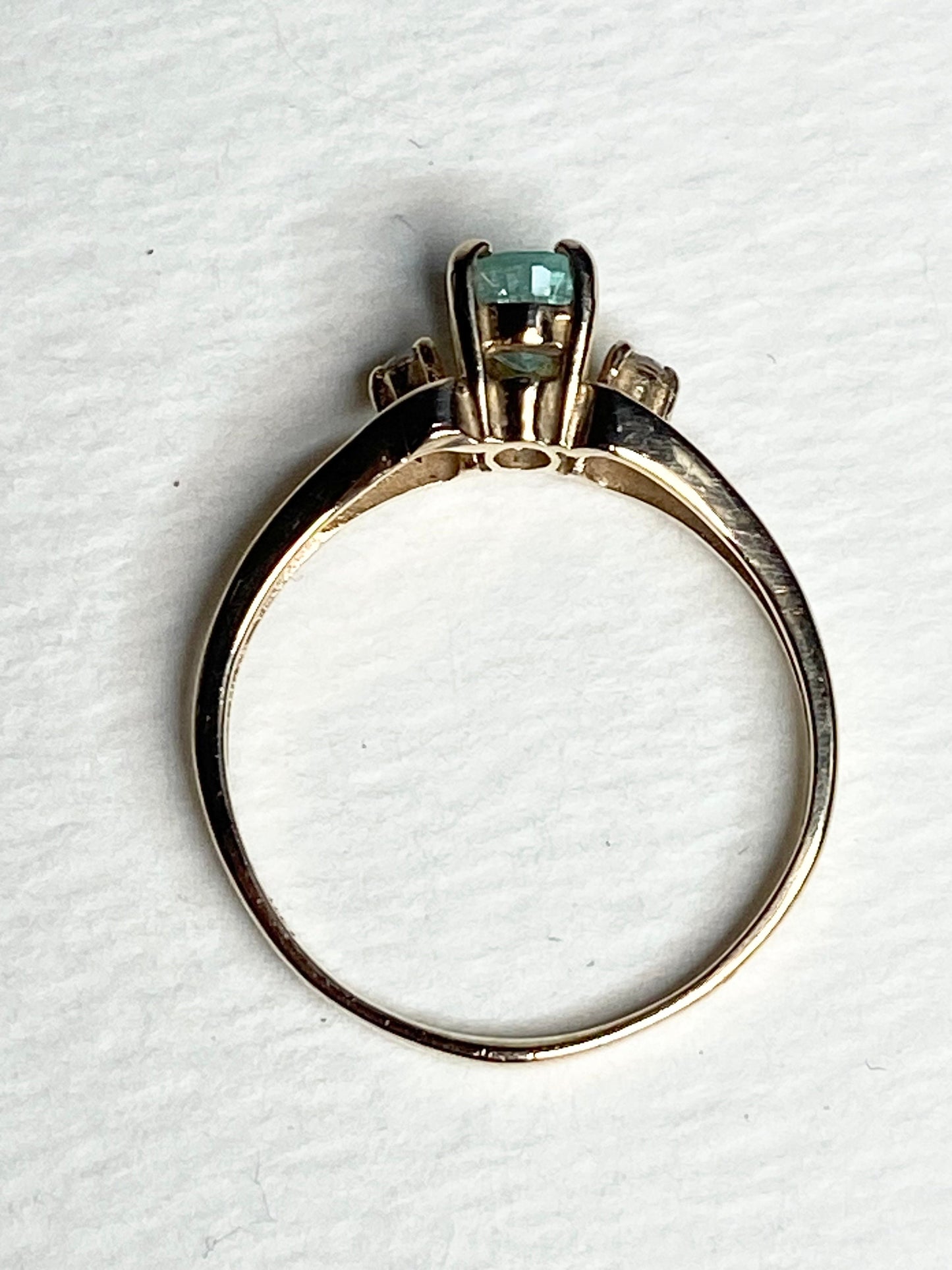 A 14k gold ring with a green tourmaline and two diamonds.