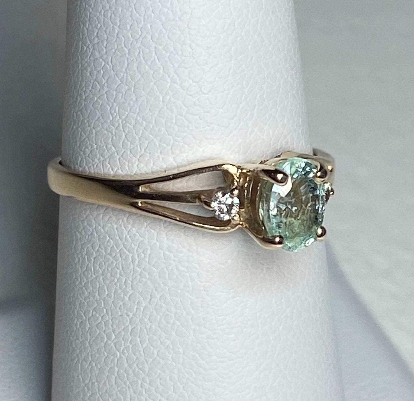 14k gold ring with oval paraiba colored tourmaline and two diamonds.