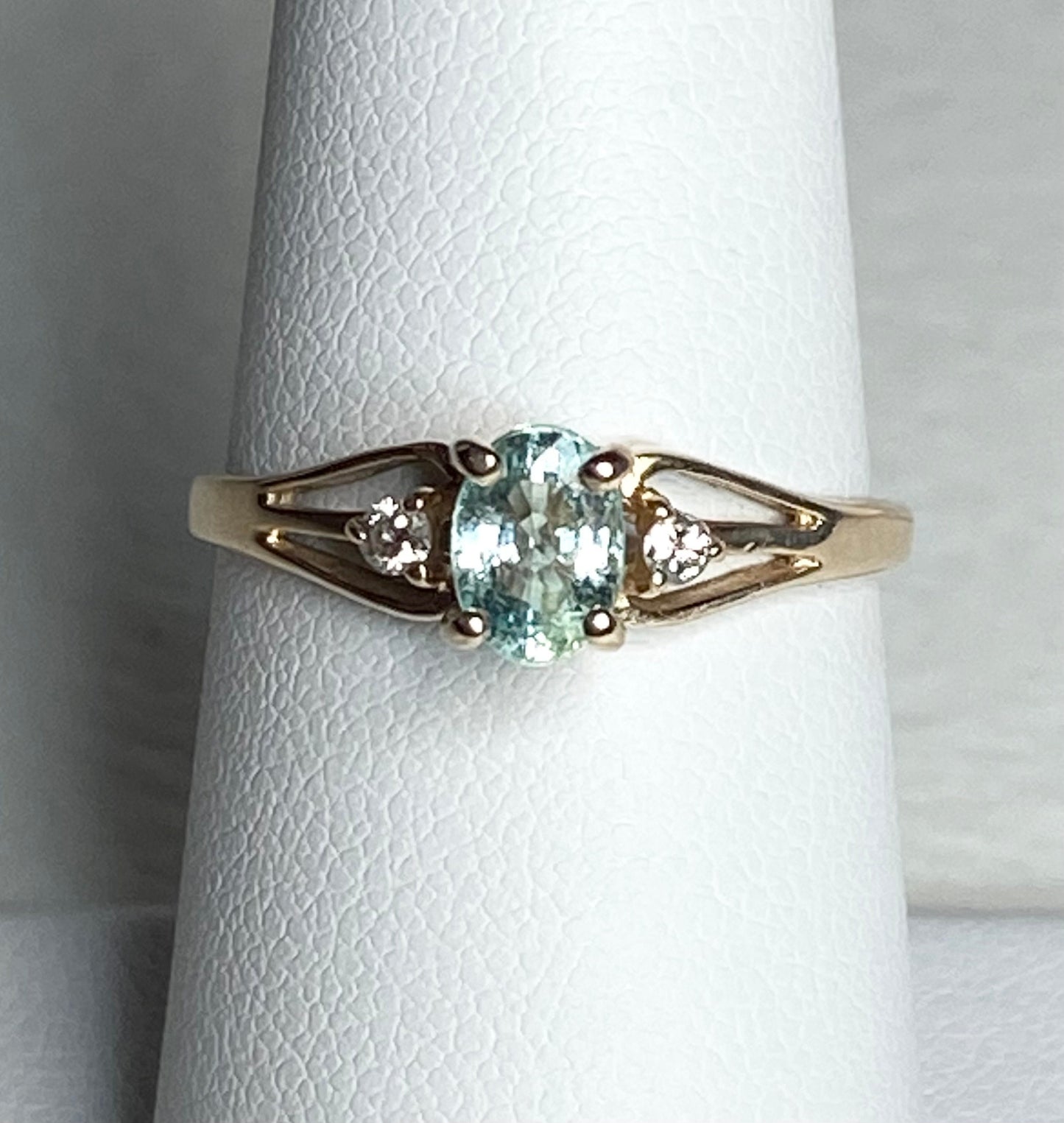 14k gold ring with oval paraiba tourmaline and two diamonds.