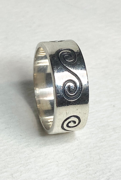 Sterling silver band ring with a swirl design.