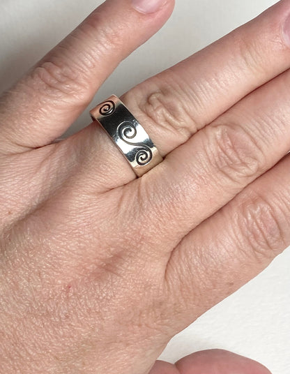 Sterling silver band ring with swirl design and Mexican hallmark.
