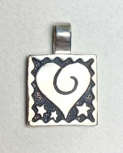 Sterling silver square pendant with a heart and stars design.