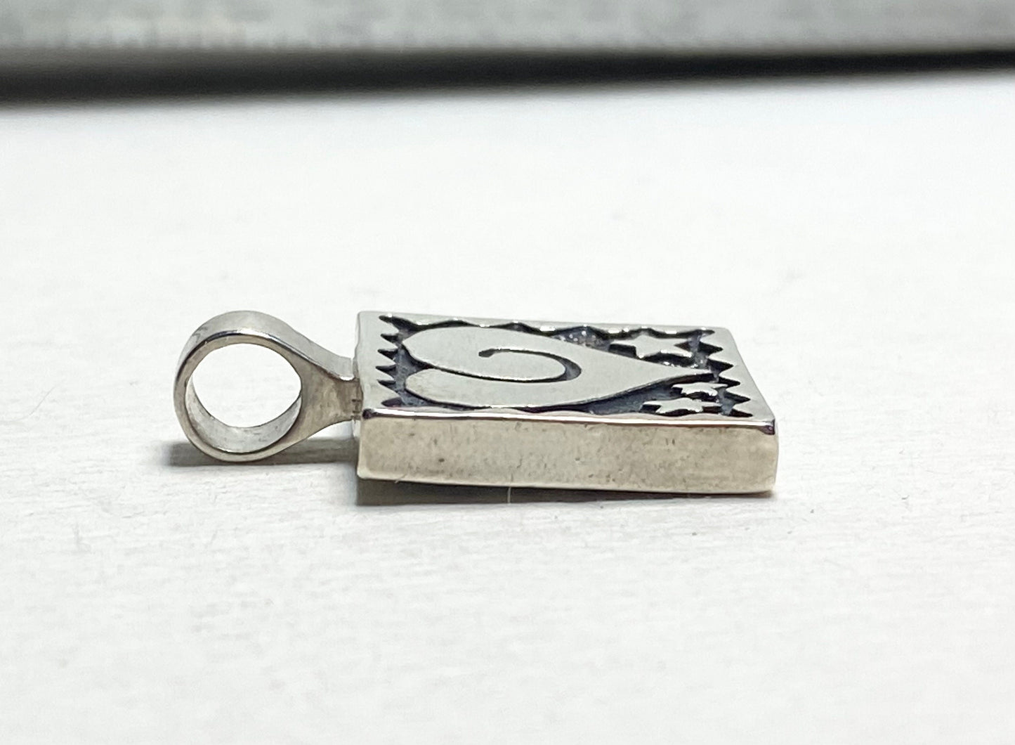 Sterling silver square pendant with heart and stars design.