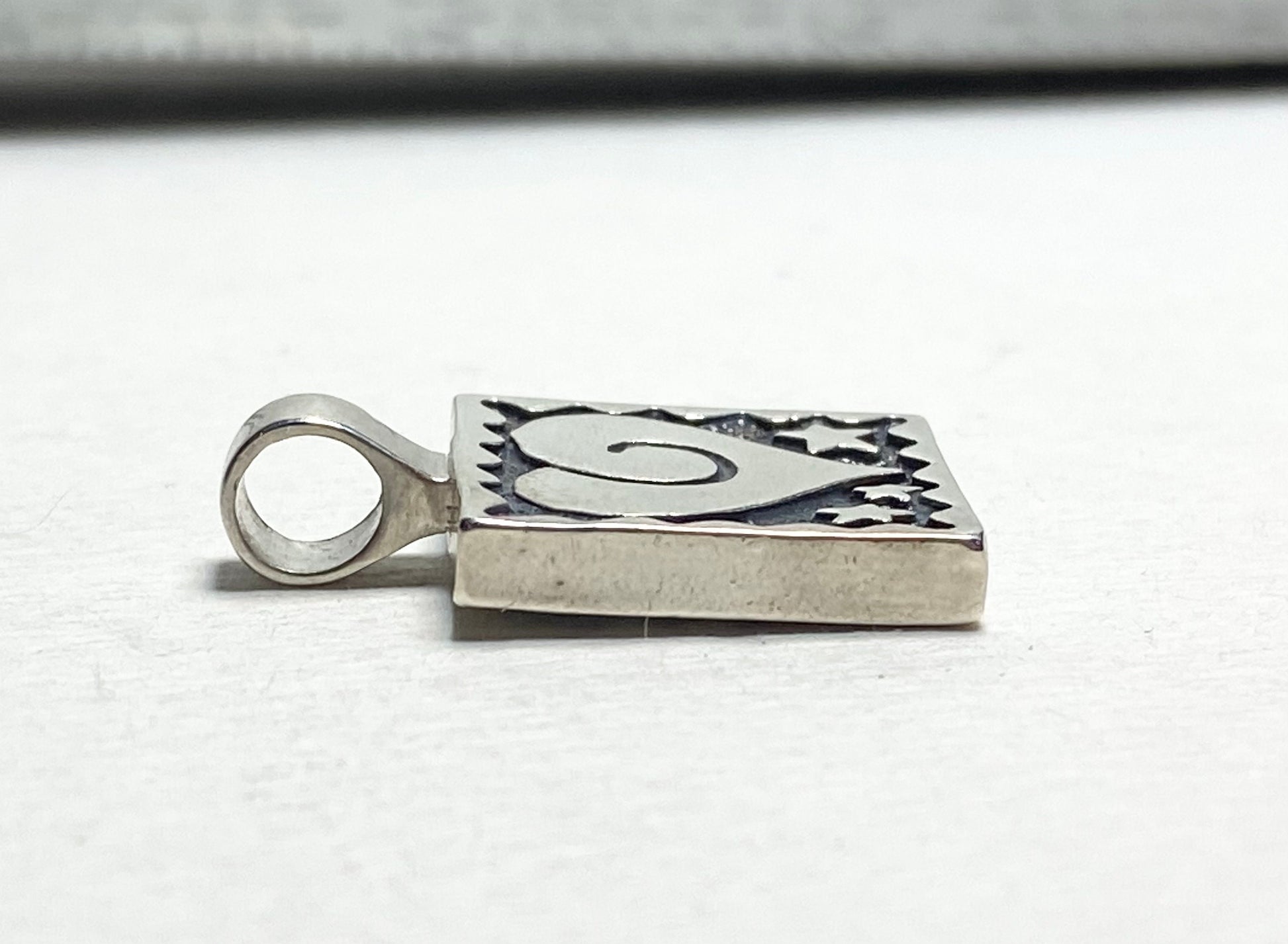 Sterling silver square pendant with heart and stars design.