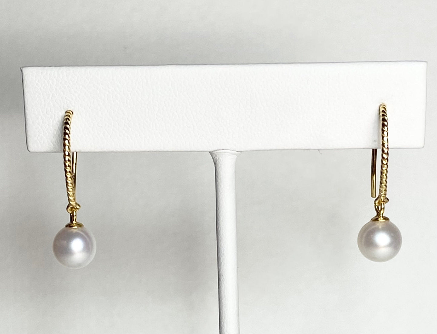 Gold plated sterling silver dangle earrings with 7mm cultured pearls and twisted wire hooks.
