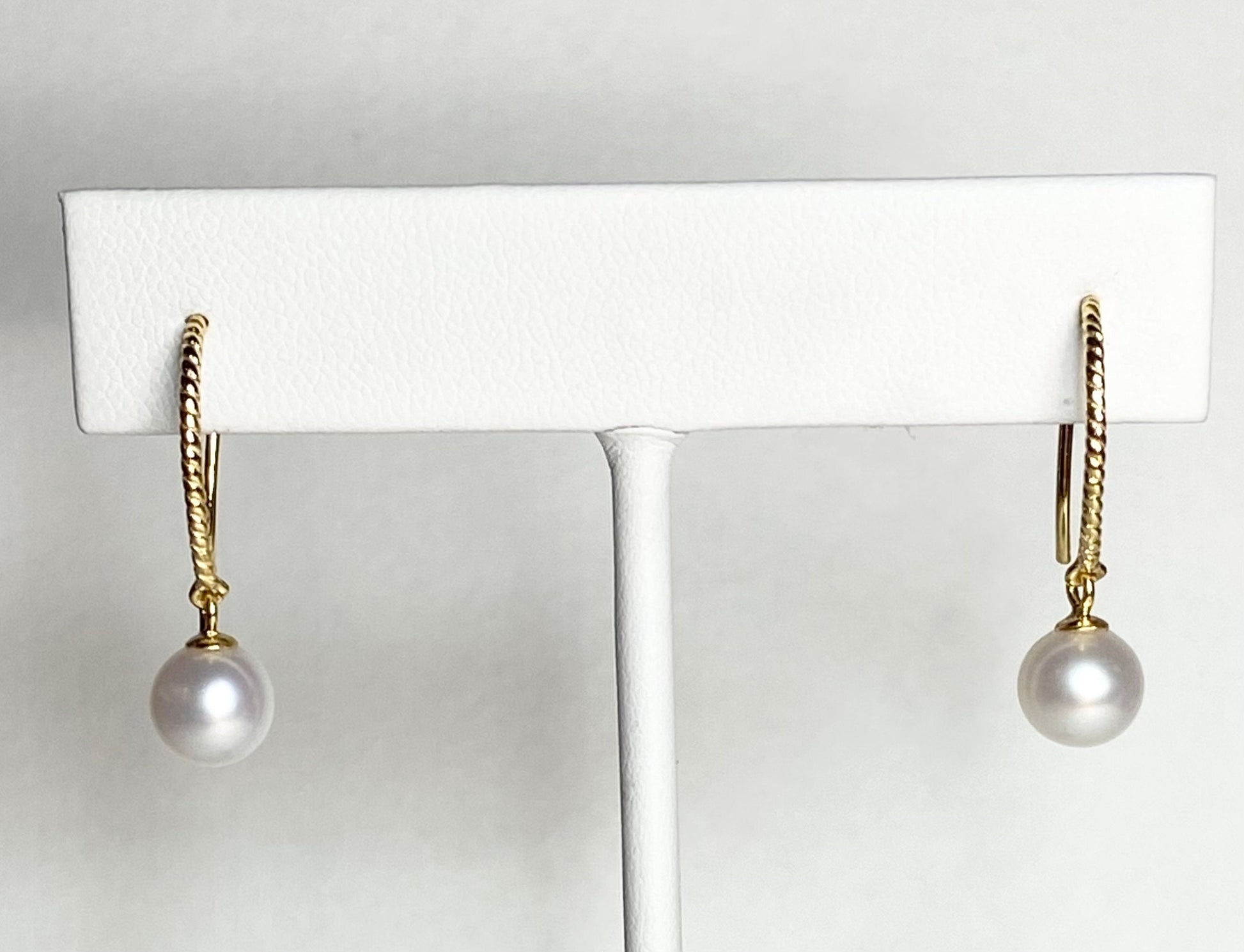 Gold plated sterling silver dangle earrings with 7mm cultured pearls and twisted wire hooks.