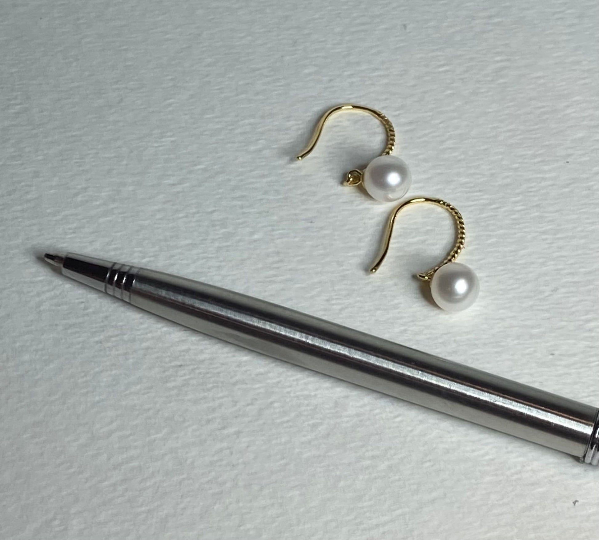 Gold plated sterling silver earrings with 7mm cultured pearls and twisted wire hooks.