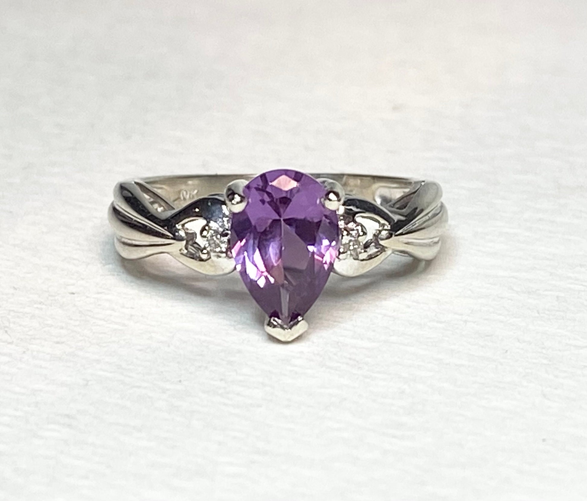 10k white gold ring with a pear-shaped synthetic color change sapphire and natural diamonds.