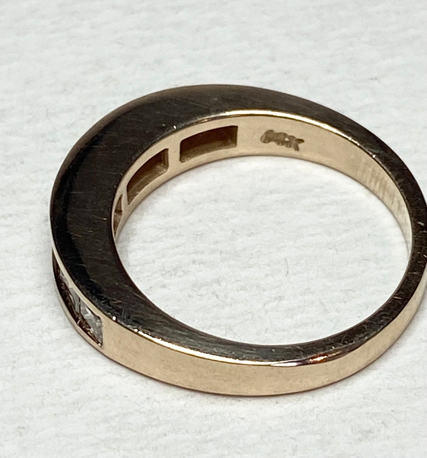 Princess cut diamond channel set anniversary band ring in 14k yellow gold.