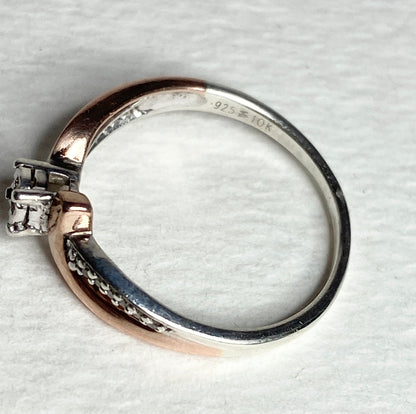 Bypass ring with rose gold and sterling silver bands, featuring diamonds.