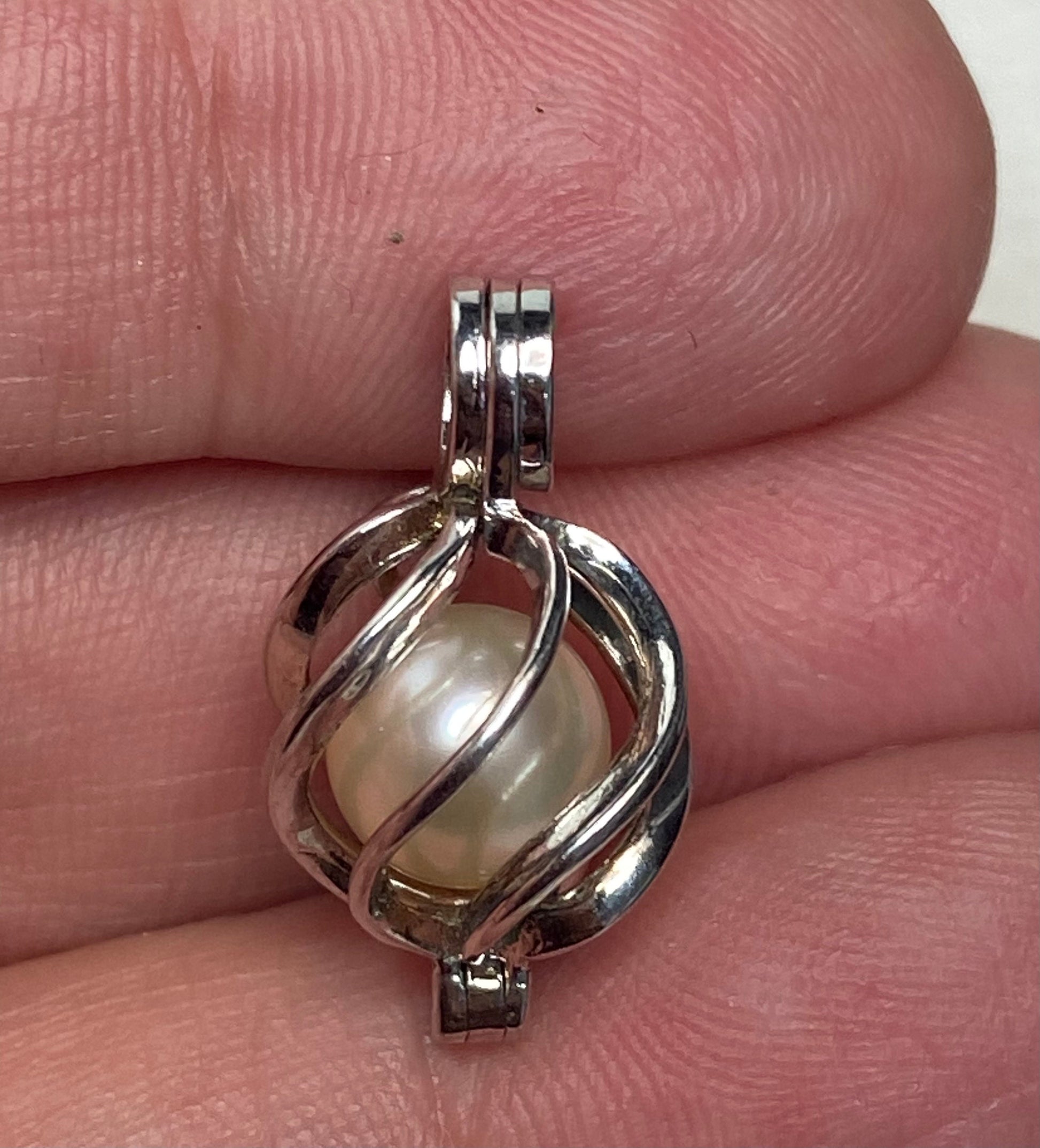 Sterling silver pendant with a soft cream Akoya pearl in a cage.