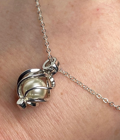 Sterling silver pendant necklace with a soft cream Akoya pearl in a cage.
