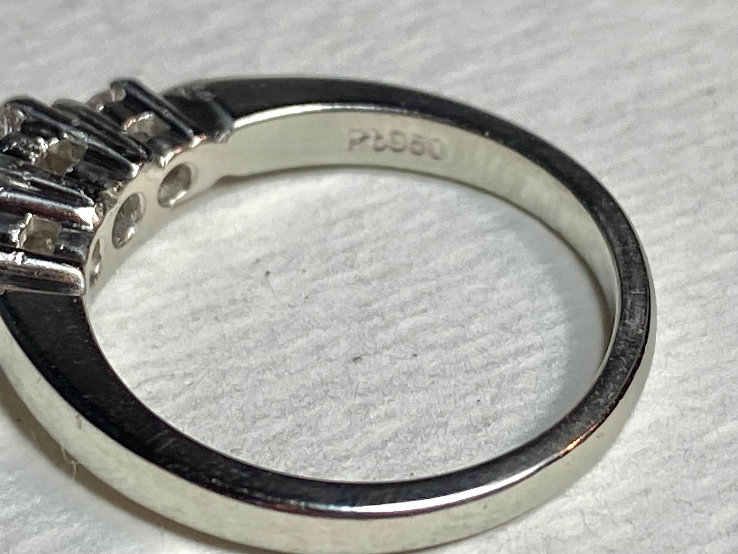 Platinum ring with a very light pink diamond and two white diamonds.