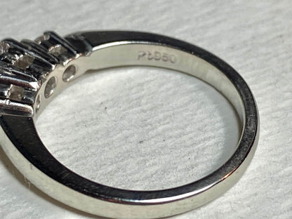 Platinum ring with a very light pink diamond and two white diamonds.