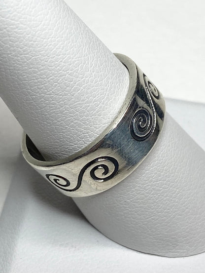 A sterling silver band ring with a swirl design.