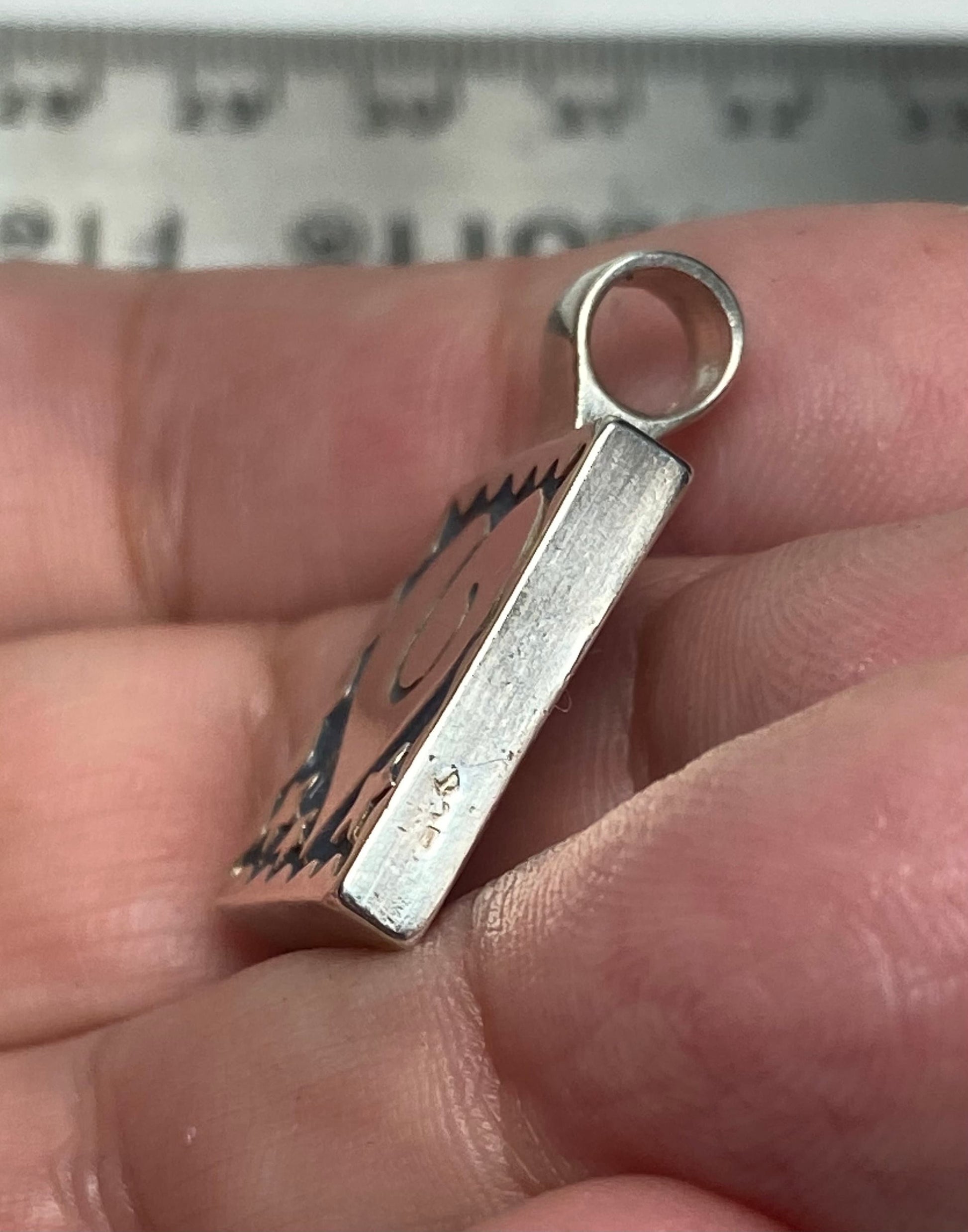 Sterling silver square pendant with heart and stars design.