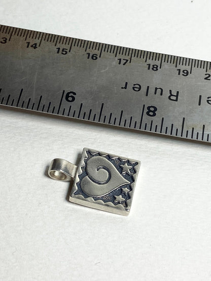 Sterling silver square pendant with a heart and stars design.