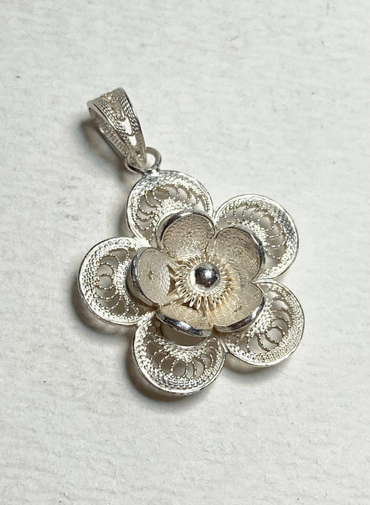 Sterling silver filigree pendant crafted in the shape of a flower.