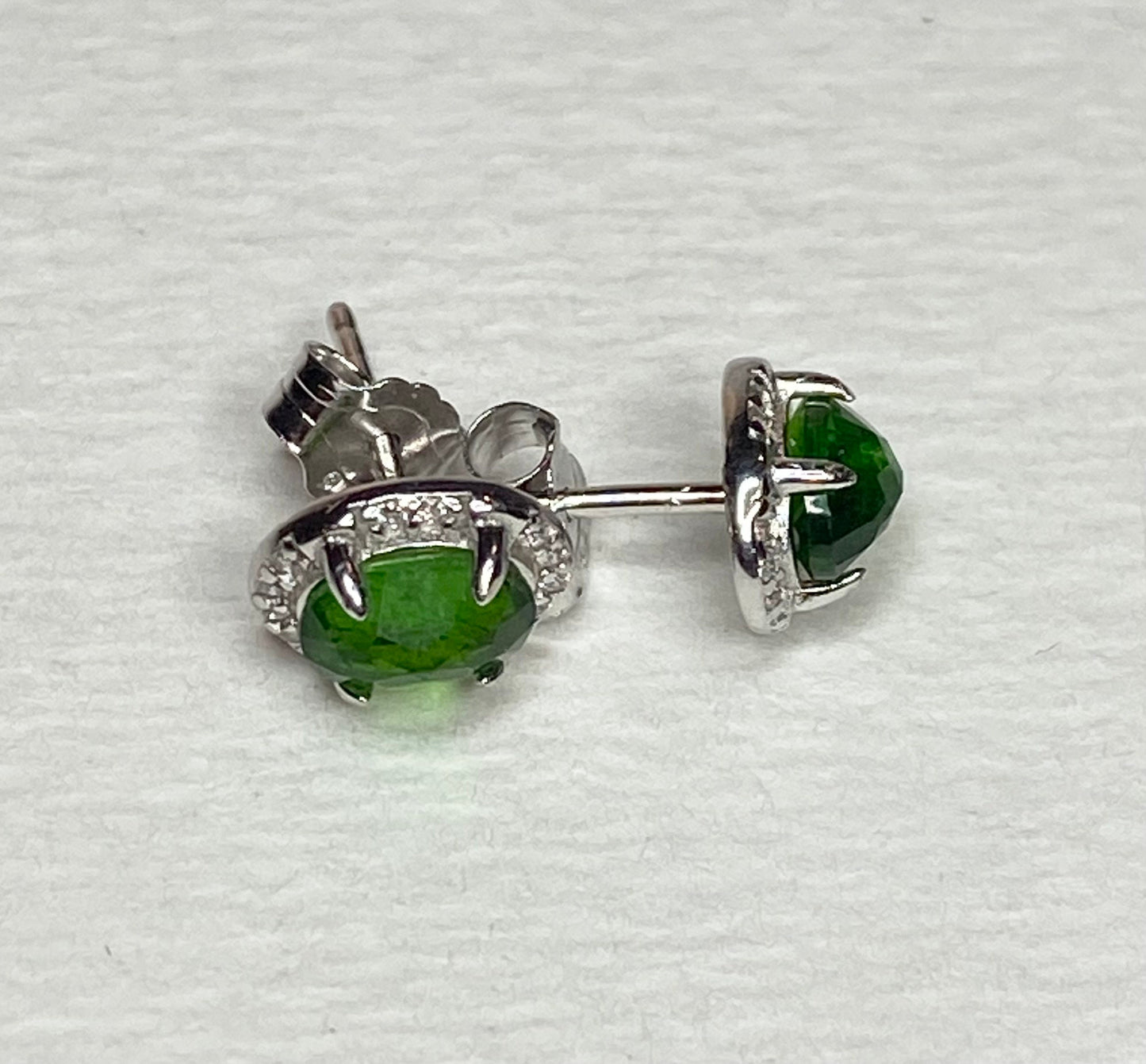 Sterling silver stud earrings with oval chrome diopside and small accent stones.