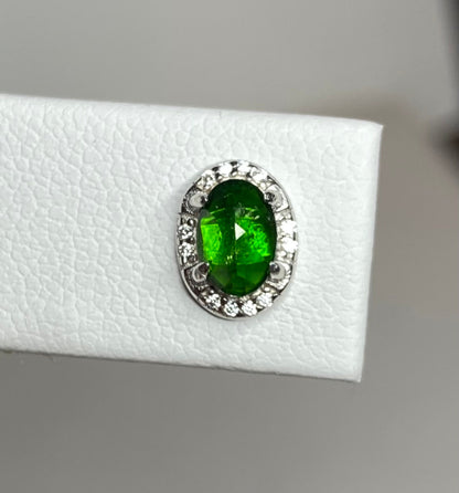 Sterling silver stud earrings featuring an oval chrome diopside gemstone surrounded by small cubic zirconia stones.