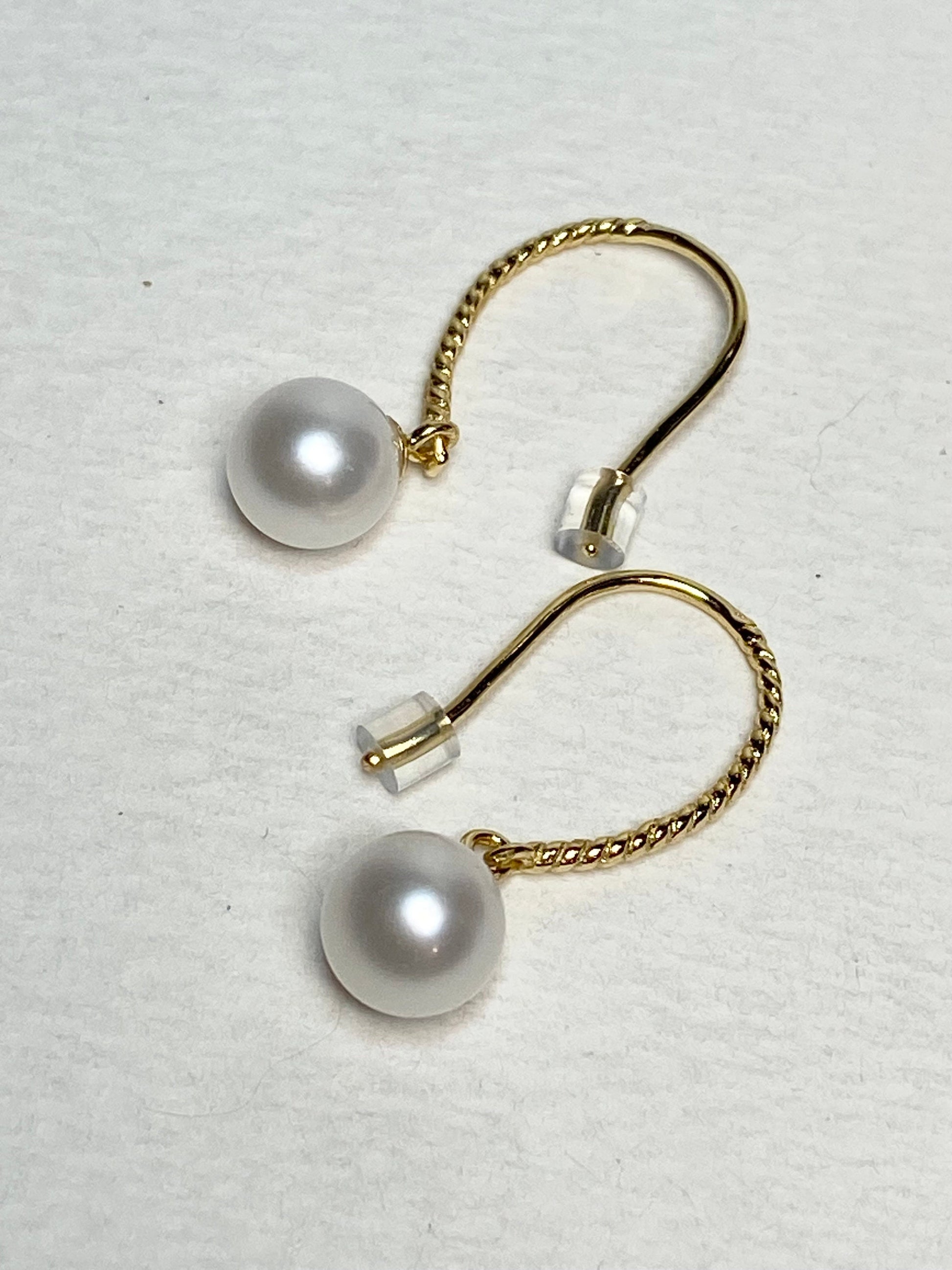 Gold plated sterling silver dangle earrings with 7mm cultured pearls and twisted wire hooks.