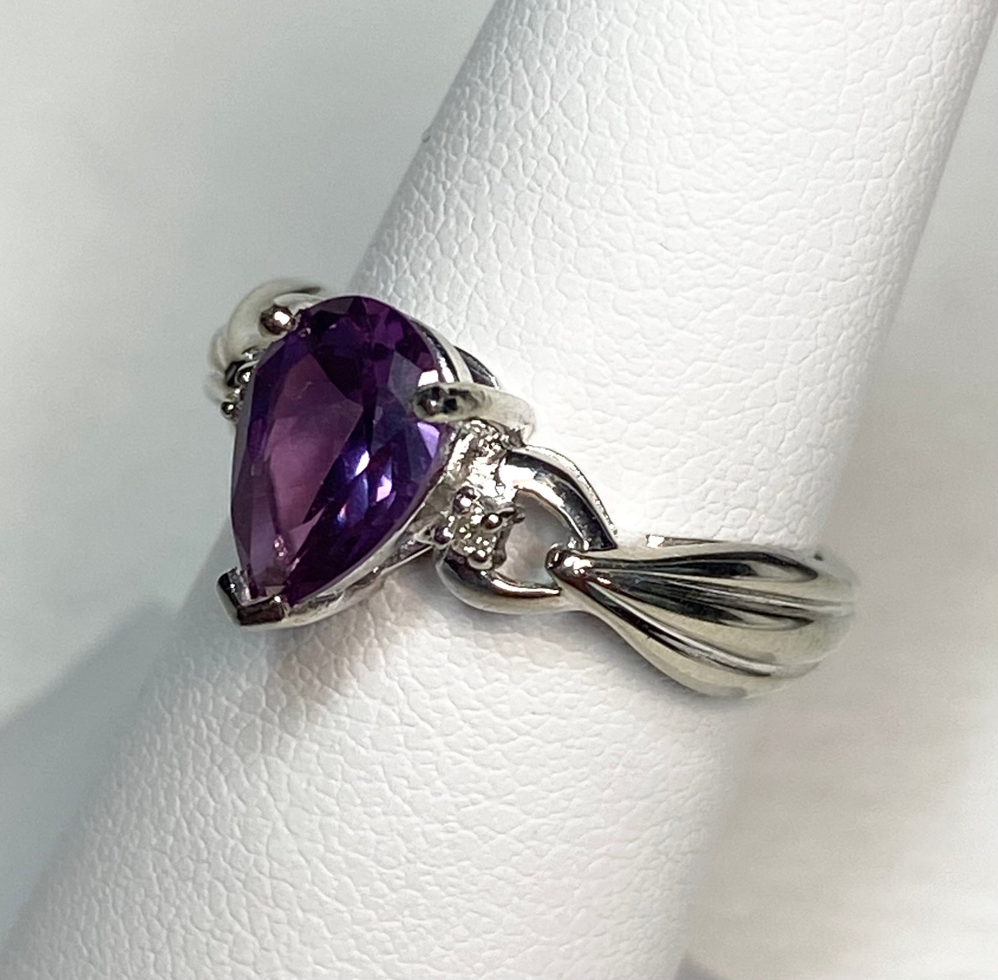 10k white gold ring with a pear-shaped synthetic color change sapphire and natural diamonds.