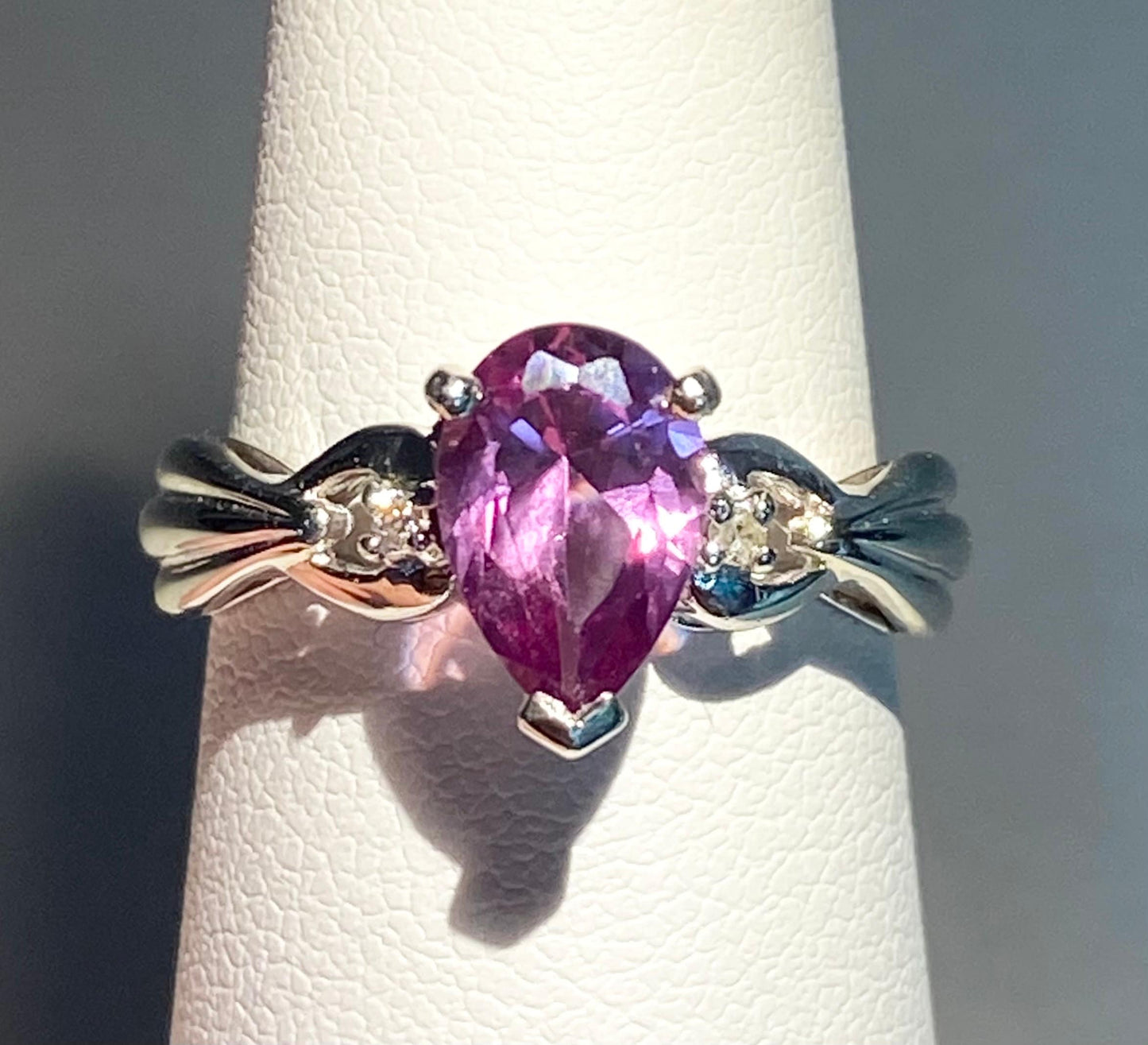 10k white gold ring with a pear-shaped color-changing synthetic sapphire and natural diamonds.