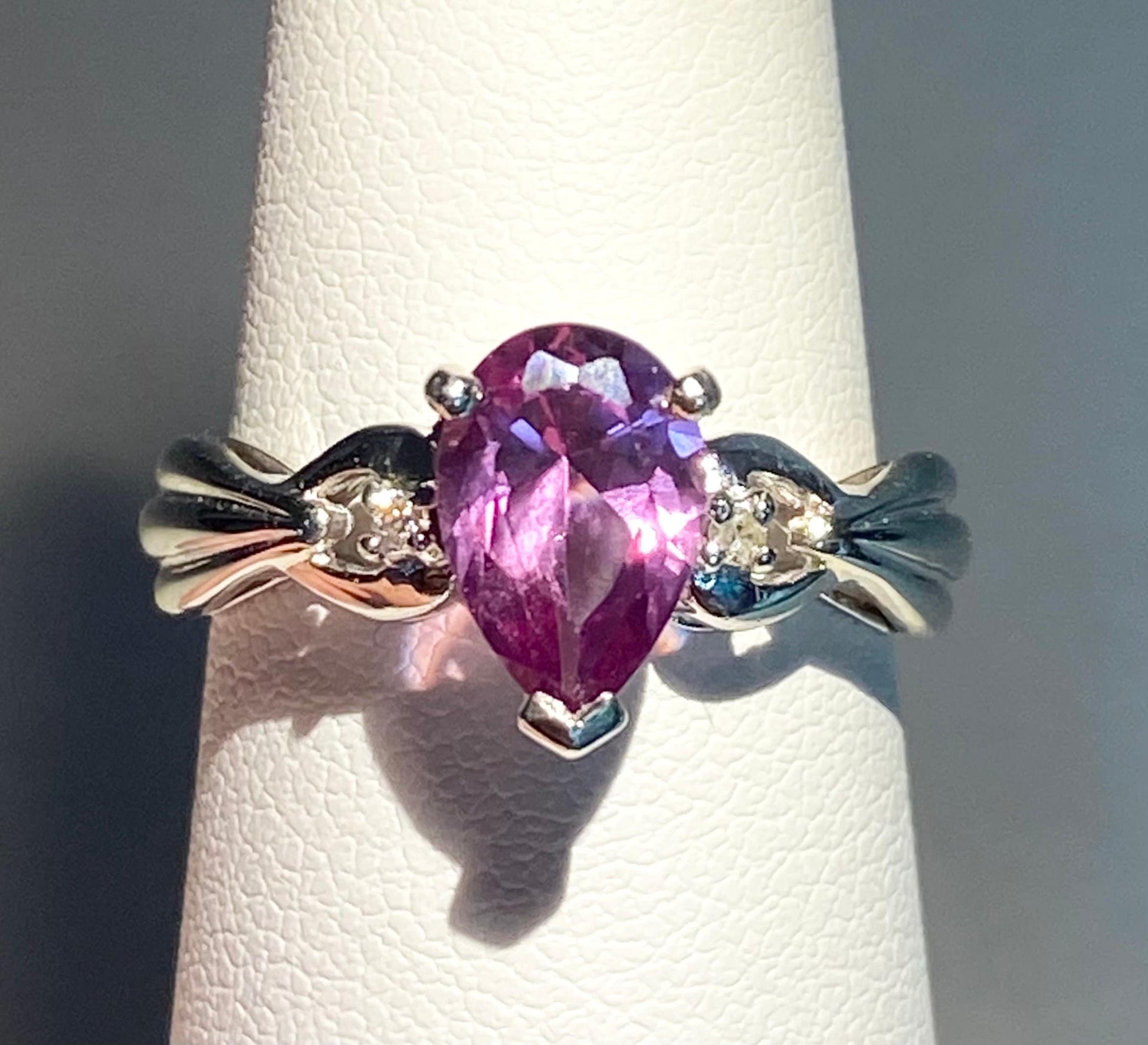 10k white gold ring with a pear-shaped color-changing synthetic sapphire and natural diamonds.