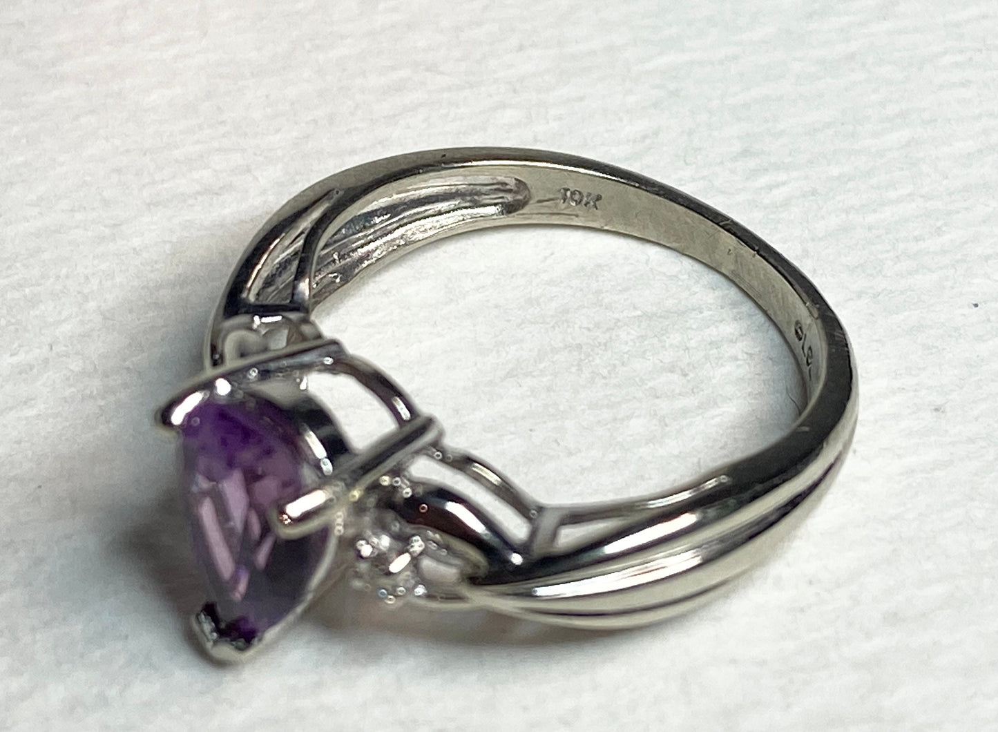 Solid 10k white gold ring with a pear-shaped synthetic color change sapphire and natural diamonds.