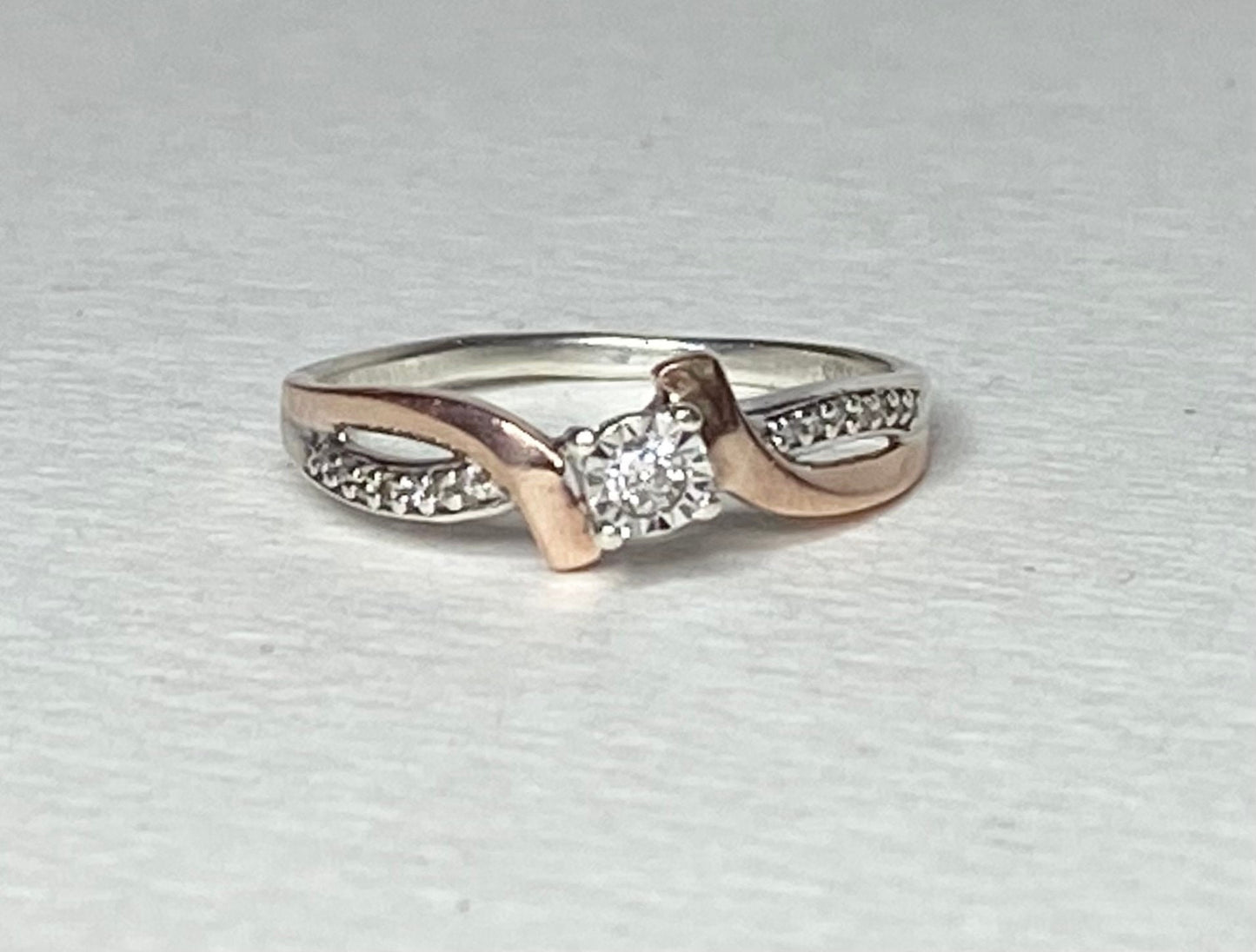 A size 7, 10k rose gold and sterling silver diamond band engagement ring.